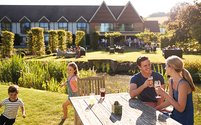 Family Enjoying Outdoor Summer Drink At Pub