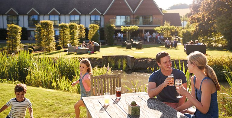 Family Enjoying Outdoor Summer Drink At Pub