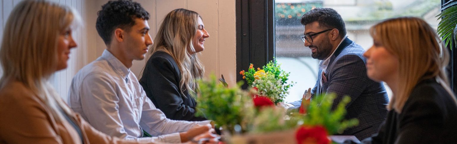5 people sat in a cafe having a discussion
