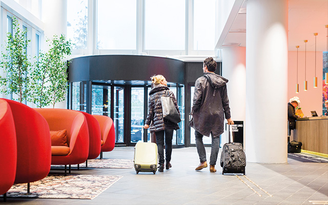 Traveler's with luggage walking through a modern hotel