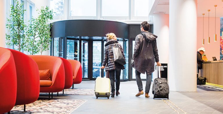 Traveler's with luggage walking through a modern hotel