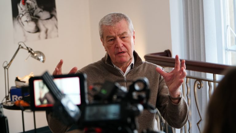 Man sitting in a chair talking to a camera