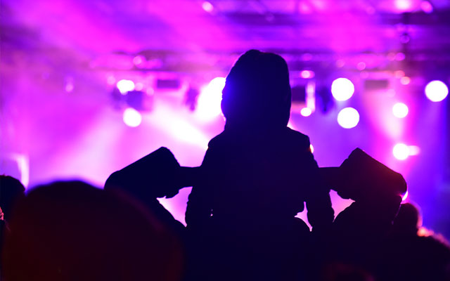 Child on shoulders watching a live event