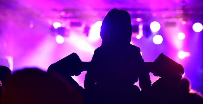 Child on shoulders watching a live event