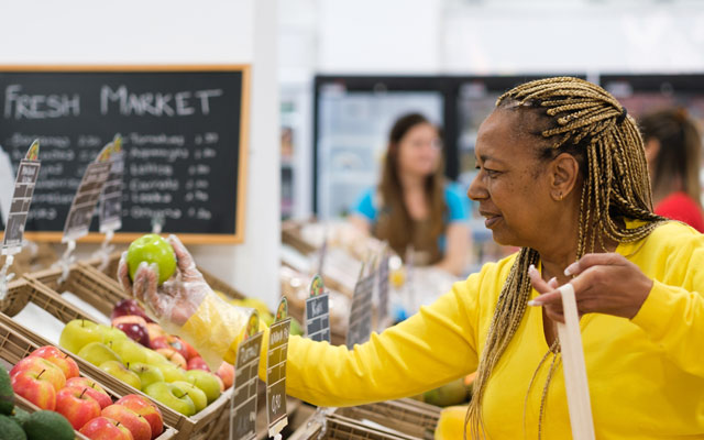Lady in a market inspecting the produce
