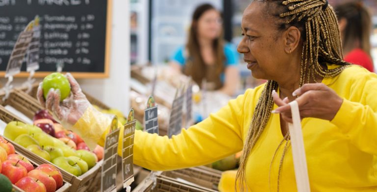 Lady in a market inspecting the produce