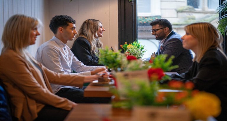 5 people sat in a cafe having a discussion